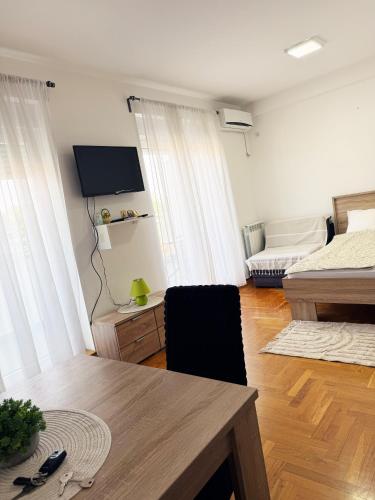 a living room with a table and a bed at Banja Koviljača Apartmani Matić in Banja Koviljača