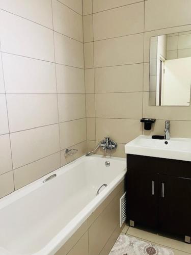 a bathroom with a bath tub and a sink at CLASSY and COZY 3 in Fourways