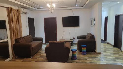 ein Wohnzimmer mit Sofas und einem Flachbildfernseher in der Unterkunft HattiHome in Freetown