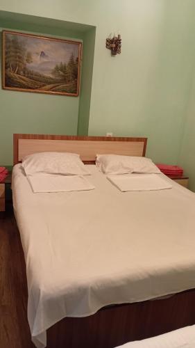 a bedroom with two beds with white sheets at Ani guest house in Meghri
