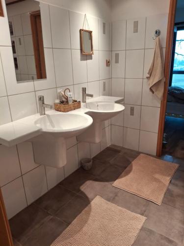 a bathroom with two sinks and two mirrors at Maison zen in Laval-Pradel