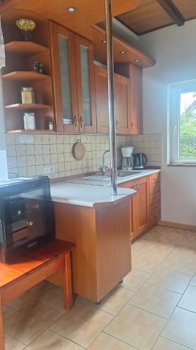 a kitchen with a sink and a tv in it at Domek nad jeziorem in Dorotowo