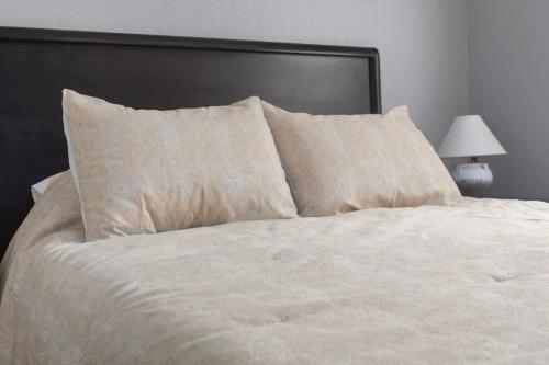 a large bed with white sheets and pillows at Olathe corporate retreat in Olathe