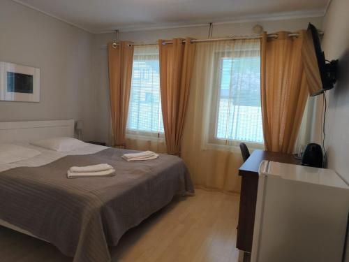 a bedroom with a bed with two towels on it at Rantakartano in Pori