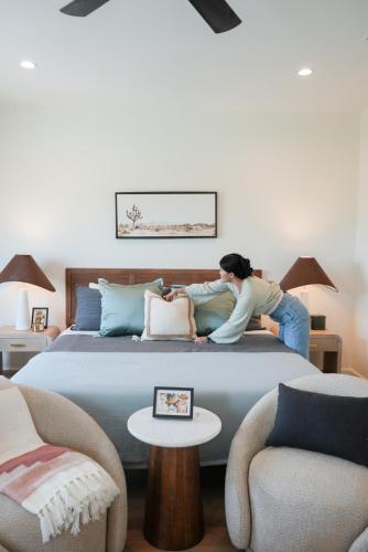 a woman standing on a bed in a bedroom at Astra B, Designer 3BR, Arcade, Heated Pool in Port Isabel