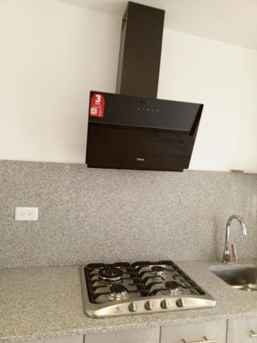 a stove top oven sitting on top of a kitchen counter at Apartamentos Latacunga in Latacunga