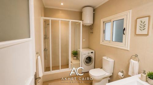 a bathroom with a toilet and a washing machine at Akhet Cairo Suites in Cairo