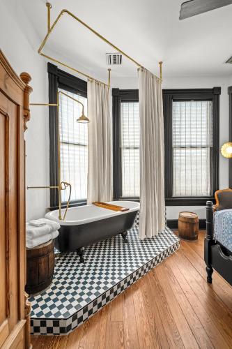a bathroom with a black tub in a room with windows at Saint Helens House-Hotel Historic District Near Cruise Port in Galveston