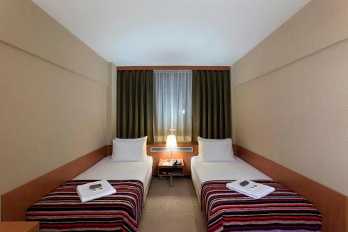 a hotel room with two beds and a window at Kent Hotel in Bursa