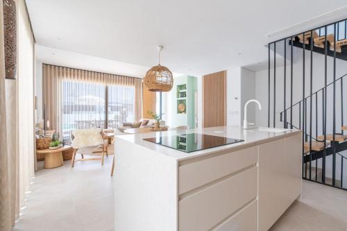 a kitchen with a white counter and a living room at Luxe zuiderse villa in Dolores