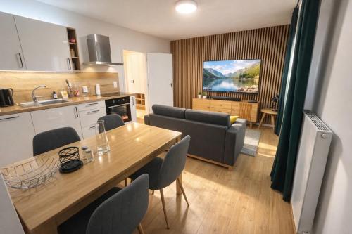 a kitchen and living room with a table and chairs at Apartmán Javorná Living in Čachrov