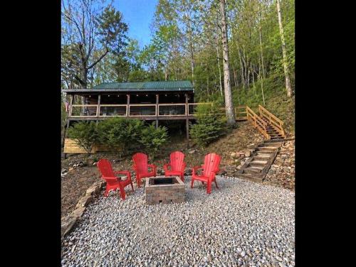 a group of red chairs sitting in front of a building at UnBearably Cozy - pool table, fire pit, central location in Bryson City