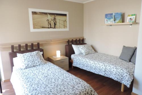 a bedroom with two beds and a picture on the wall at B&B Casa Vanzetta in Ziano di Fiemme