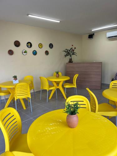 a dining room with yellow tables and chairs at Pousada Mar de Pajuçara in Maceió