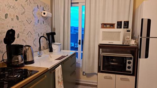 a kitchen with a refrigerator and a microwave at Pousada Canto Bonito centro de Rolante in Rolante