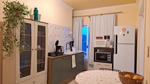a kitchen with a refrigerator and a table in a room at Pousada Canto Bonito centro de Rolante in Rolante