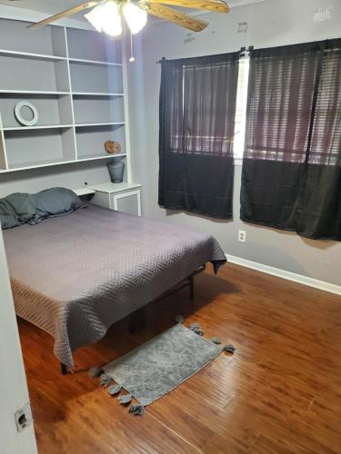 a bedroom with a bed with a rug and a window at Comfortable home in Mobile