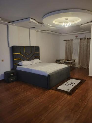 a bedroom with a king sized bed and a table at HattiHome in Freetown