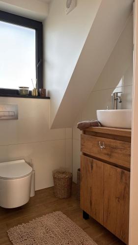 a bathroom with a sink and a toilet and a window at Chwila Pauzy in Tolkmicko