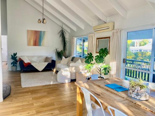 a living room with a table and a couch at Tairua Tides - Relaxed Coastal Retreat in Tairua
