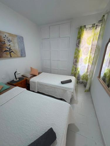 a small room with two beds and a window at Orlando Costa Adeje in Adeje