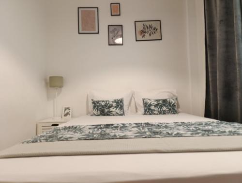 a bedroom with a white bed with two pillows at DOWNTOWN 4 in Alexandroupoli