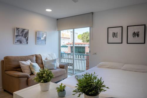 a living room with a bed and a couch at Acogedor studio a 10min de la playa in Torredembarra
