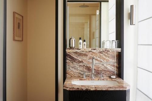 a bathroom with a sink and a mirror at Hôtel Atlas in Paris