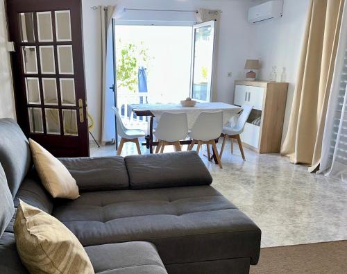 a living room with a couch and a table with chairs at Sweet Home in Miranda do Douro