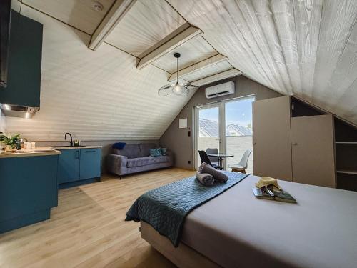 a large bedroom with a large bed and a kitchen at Morski Raj Apartamenty in Dębki