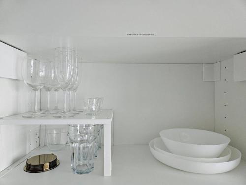 a white room with glasses on a shelf at Royal View Apartment in Liepāja