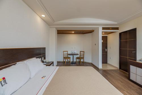 a hotel room with a bed and a table at Hotel & Villas Panamá in Mexico City