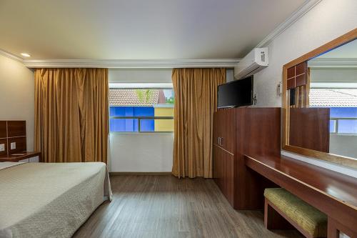 a hotel room with a bed and a mirror at Hotel & Villas Panamá in Mexico City