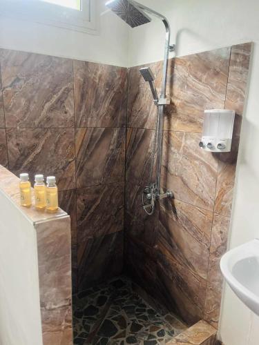 a shower with a glass door in a bathroom at Bungalow tatayo in Aua