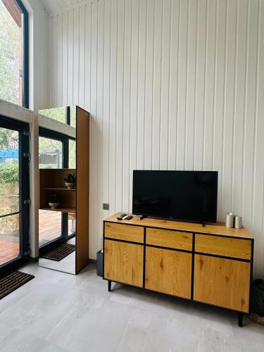 a living room with a television on a wooden cabinet at Cabana Pescarului in Corabia