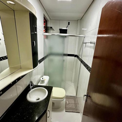 a bathroom with a shower and a toilet and a sink at Loft Lux SM Chapecó - Amplo e aconchegante! in Chapecó