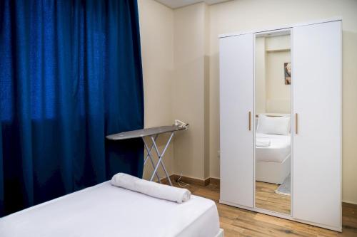 a bedroom with a bed and a blue curtain at 407. Spacious 3BR Apt. 2 Baths Gated Community in Sheikh Zayed