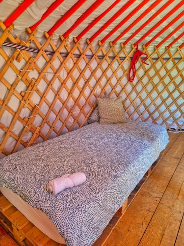 a bed in a yurt with a pink pillow on it at Les Cabanes d Erhes in Saint-Pé-de-Bigorre
