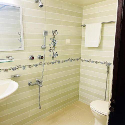 a bathroom with a shower with a toilet and a sink at Elegant Residence Guest House in Dhaka