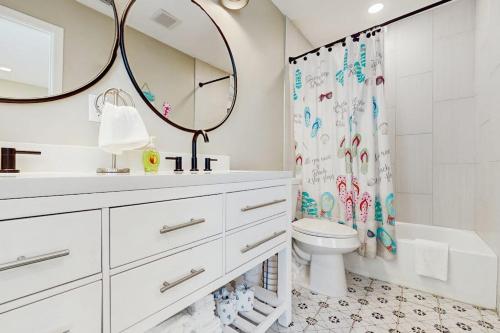 a bathroom with a sink and a toilet and a mirror at Emerald Escape in Corpus Christi