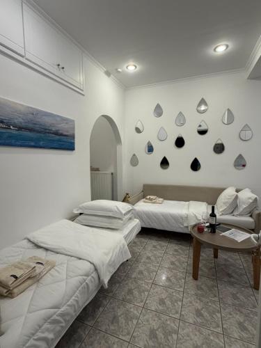two beds in a room with a table and a painting at Agia Anna Horizon in Kranidi
