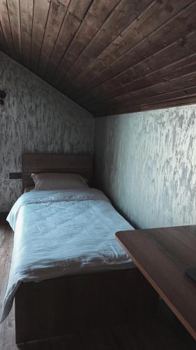 a bed in a room with a wooden ceiling at Arcadia Family Vacation House in Çilǝgir