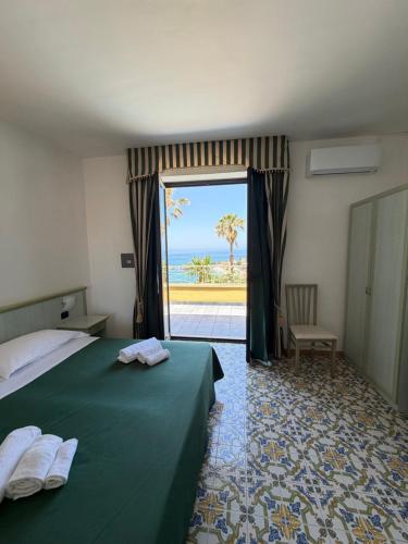 a hotel room with a bed and a view of the ocean at Belvedere Blu b&b & beach in Belvedere Marittimo
