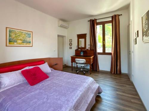 a bedroom with a bed and a desk and a window at Ramoscello in Altare