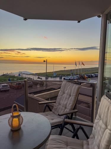 a patio with a table and chairs and a view of the beach at Casa Amare in Egmond aan Zee