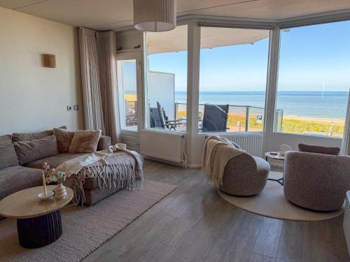 a living room with a couch and a view of the ocean at Casa Amare in Egmond aan Zee