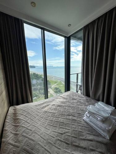 a bedroom with a bed with a view of the ocean at Tropical Garden apart hotel in Batumi