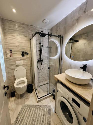 a bathroom with a shower and a toilet and a sink at Tropical Garden apart hotel in Batumi