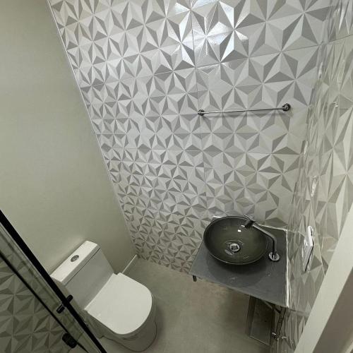 a bathroom with a toilet and a sink at Loft Lux SM Chapecó com excelente localização! in Chapecó
