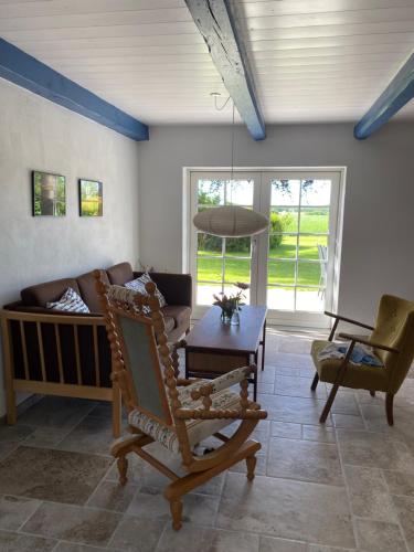 a living room with a couch and a table at Uggerhøjvej Gårdhygge in Hjørring